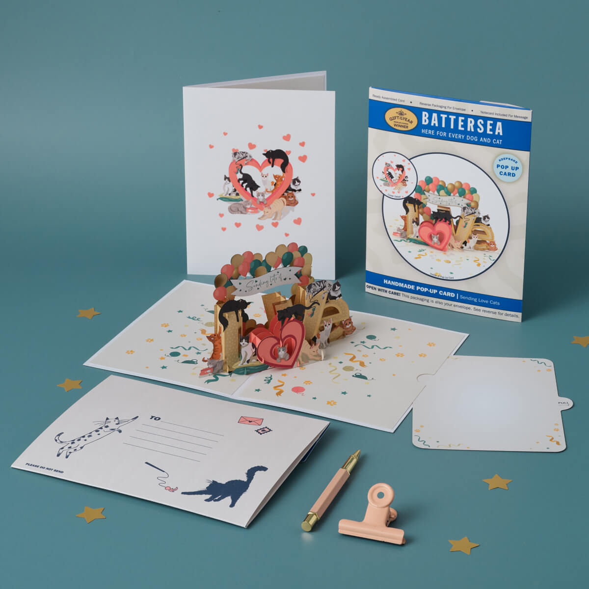 Battersea Cats Love Pop Up Card by Cardology which is perfect for Valentine's Day Cards, Mother's Day Cards, Father's Day Cards or even for Birthday Cards or Anniversary Cards. Pet mum and dad cards. This is a lifestyle image of the 3D Cats Card open with the notecard, card cover, reversible envelope and packaging all displayed.