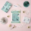 Load image into Gallery viewer, Christmas Battersea Cats Gift Wrapping Paper Set of 4 sheets - lifestyle image of pack which contain 2 different patterns