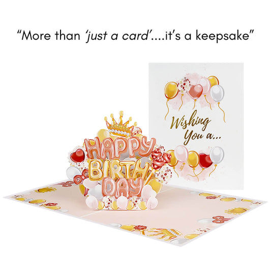 Birthday Balloons Pop Up Card for Tweens, Teens, Girls and Women featuring a rose gold, gold and ivory balloon lettering spelling out Happy Birthday, surrounded by hearts, crown and bows. Image shows card open with another card closed behind it to show the card cover.