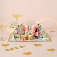Load image into Gallery viewer, lifestyle image of the celebratory love pop up card which is perfect for weddings, engagements and anniversaries - by Cardology