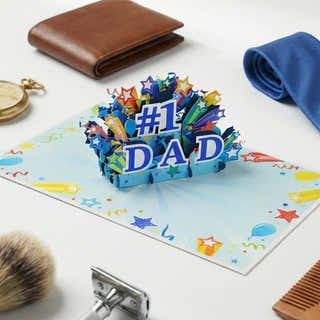 lifestyle image of the fathers day '#1 DAD' card on a table with a wallet, towel, and shaving products.