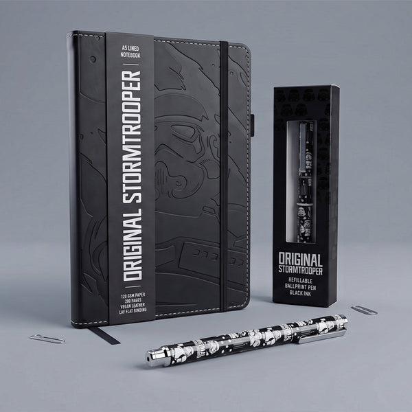 A Stormtrooper-themed stationery gift set featuring a black embossed hardcover in vegan leather A5 notebook, a black refillable ballpoint pen with a white stormtrooper helmet pattern, and their respective retail packaging boxes on a neutral gray background.
