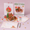 Load image into Gallery viewer, Santa Bear Christmas Pop Up Card by Cardology - lifestyle image showing santa bear christmas card open with envelope and notecard