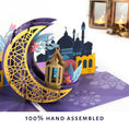 Load image into Gallery viewer, close up lifestyle image of eid card with text '100% Hand Assembled'