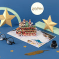 Load image into Gallery viewer, Harry Potter Christmas Pop Up Card - Lifestyle Image with card open, in a lifestyle setting with props