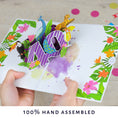 Load image into Gallery viewer, image showing hands holding the tropical 40th birthday pop up card open