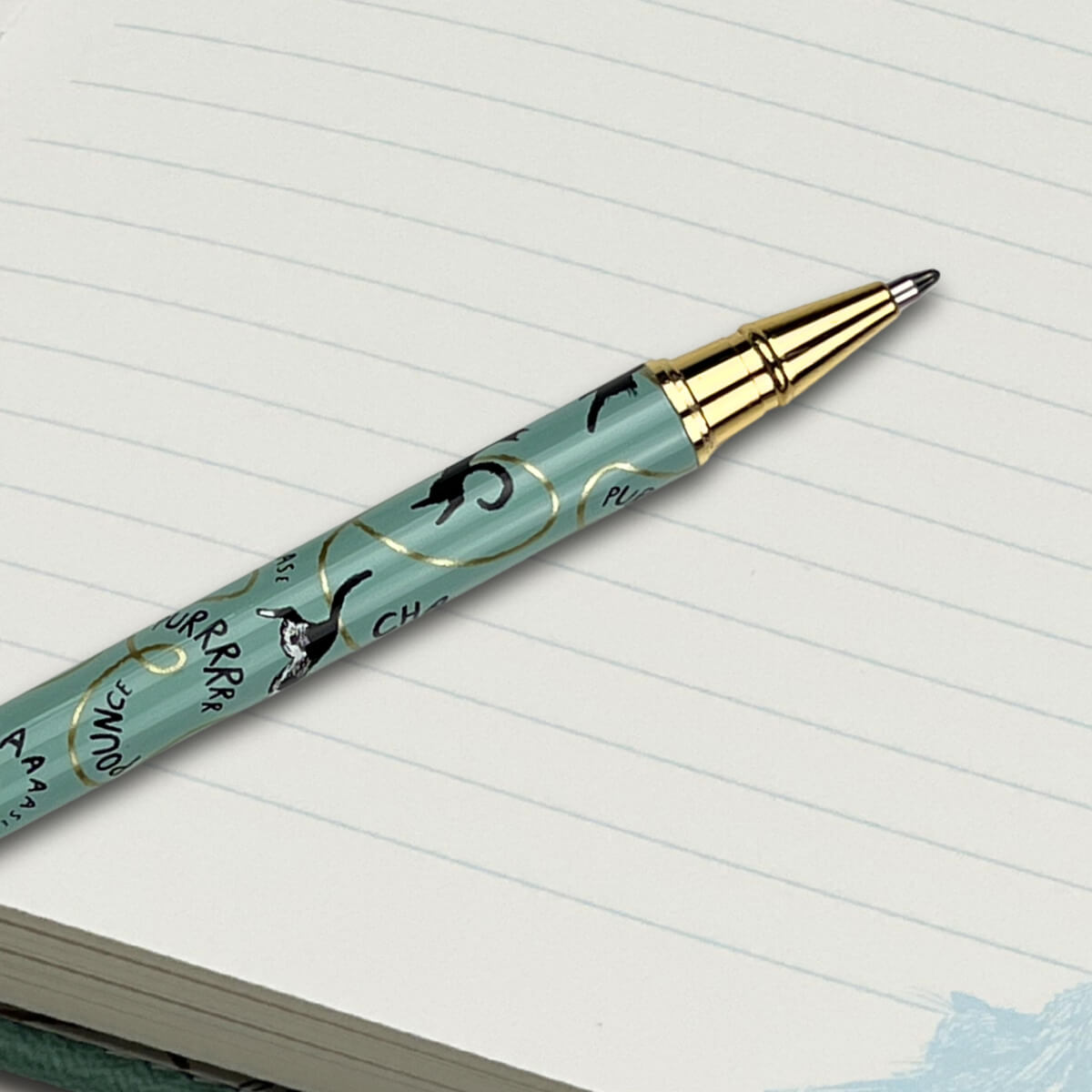 seafoam green ballpoint pen with cats illustrations in black, white and gold
