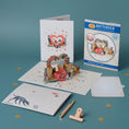 Load image into Gallery viewer, Battersea Dogs Love Pop Up Card by Cardology which is perfect for Valentine's Day Cards, Mother's Day Cards, Father's Day Cards or even for Birthday Cards or Anniversary Cards. Pet mum and dad cards. This is a lifestyle image of the 3D Dogs Anniversary Card open with the notecard, card cover, reversible envelope and packaging all displayed.
