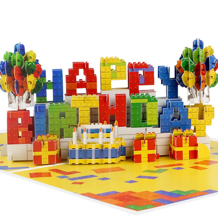 Birthday Bricks Pop Up Card for kids and adults who like building. Close up image of the pop up card which spells out Happy Birthday in colourful bricks with balloons either side.