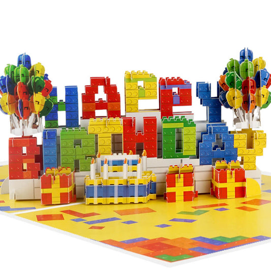 Birthday Bricks Pop Up Card for kids and adults who like building. Close up image of the pop up card which spells out Happy Birthday in colourful bricks with balloons either side.