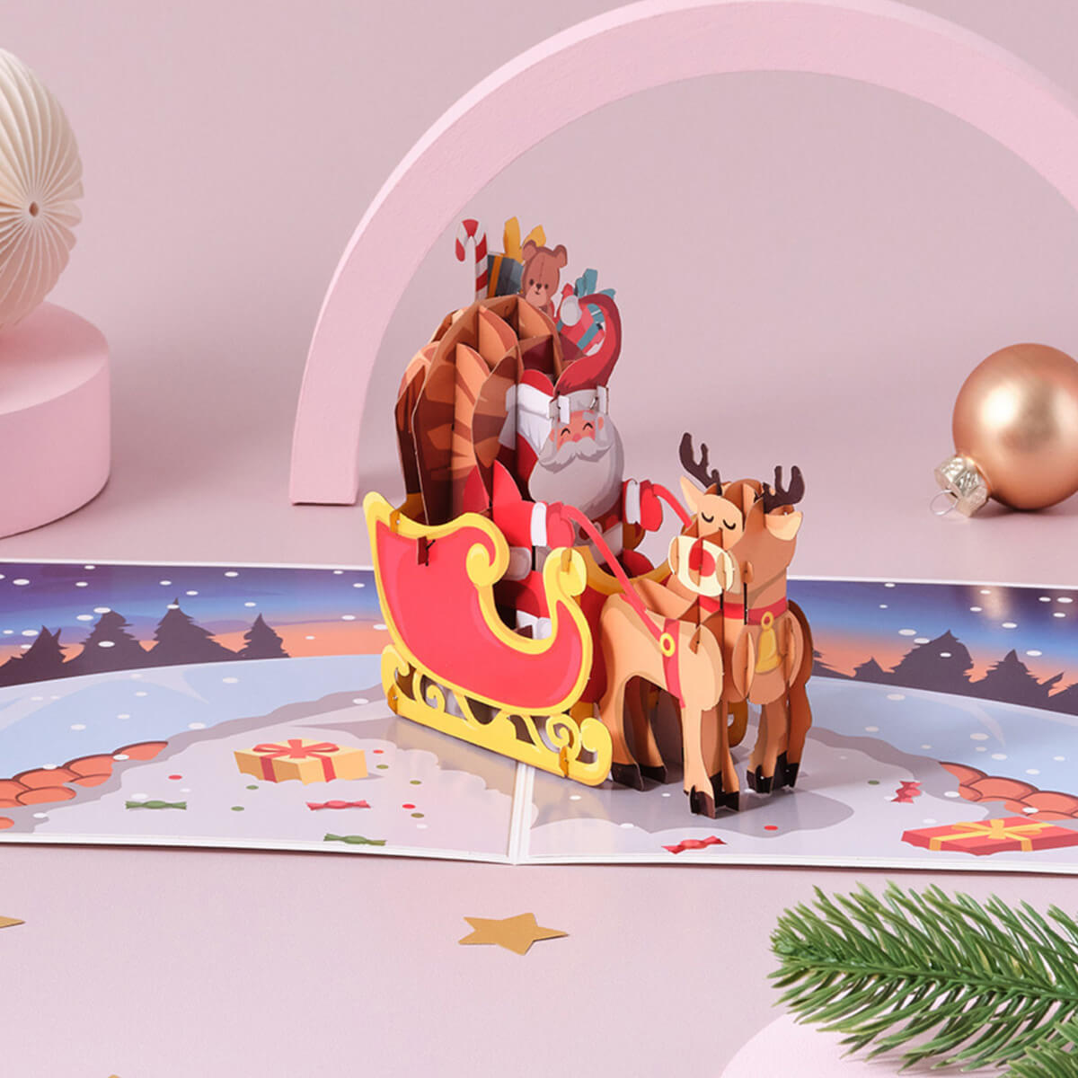 Santa’s sleigh pop-up card fully open, showing Santa Claus and his reindeer in 3D flying over a town on Christmas Eve.