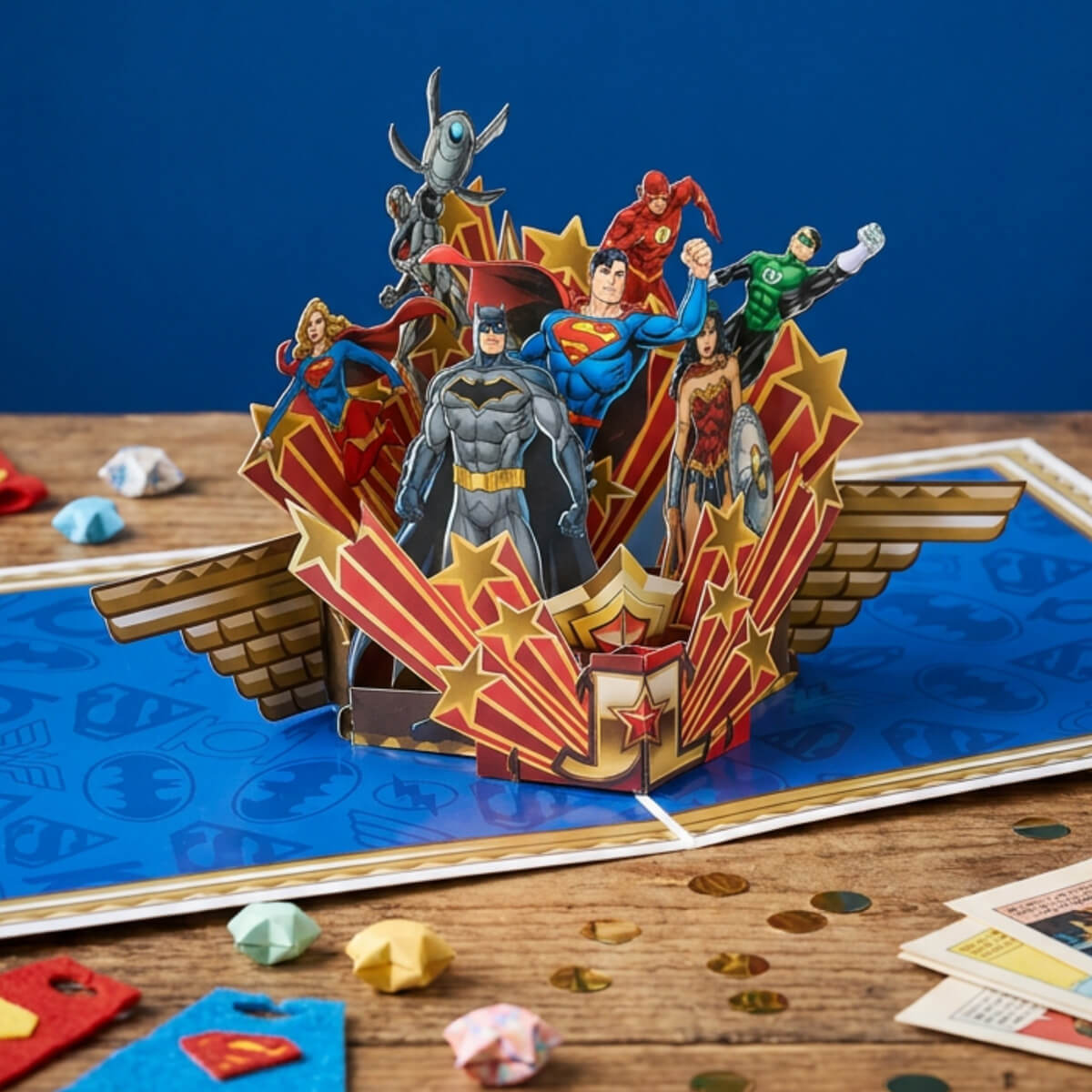 3D Justice League pop-up card with superhero figures on a wooden table