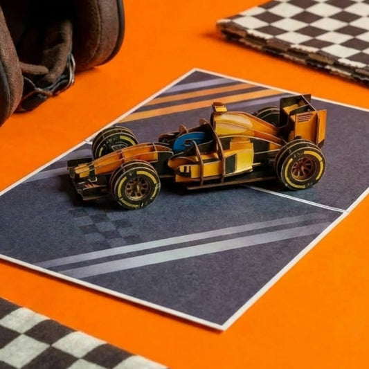 Formula 1 Car 3D Card on a orange backdrop with a helmet and additional props in the background.