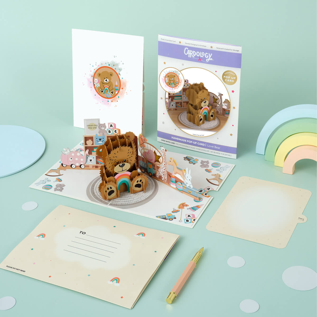 Image of Cardology New Baby Bear Pop Up Card which is also perfect as a first birthday card and gift. Image shows card fully open with the reversible envelope, the card front cover, packaging and slide out notecard