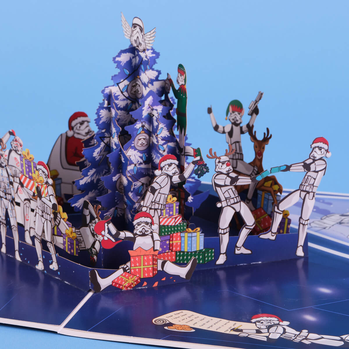 Original Stormtrooper Christmas Pop Up Card for Star Wars fans - close up lifestyle image of the pop up card highlighting the details such as stormtroopers exchanging gifts, pulling crackers, playing jokes on each other and decorating the christmas tree