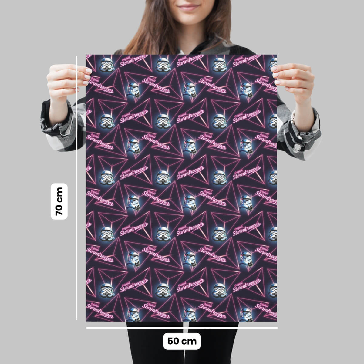 Person holding a gift wrap sheet for the Original Stormtrooper Retro design, with dimensions on a grey background. Dimensions are 50cm x 70cm