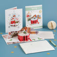 Load image into Gallery viewer, Cardology Robin Pop Up Card for Christmas - lifestyle image of the 3D Robin card which shows the card open, card front cover, notecard and reversible festive envelope
