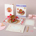 Load image into Gallery viewer, Image of Love Bear Pop Up Card showing all components of the card including the pop up card, card front cover, packaging, reversible envelope and slide out notecard
