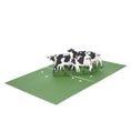 Load image into Gallery viewer, Friesian Cows Pop Up Card featuring 4 3D cows standing next to each other grazing, fully open at 180 degrees
