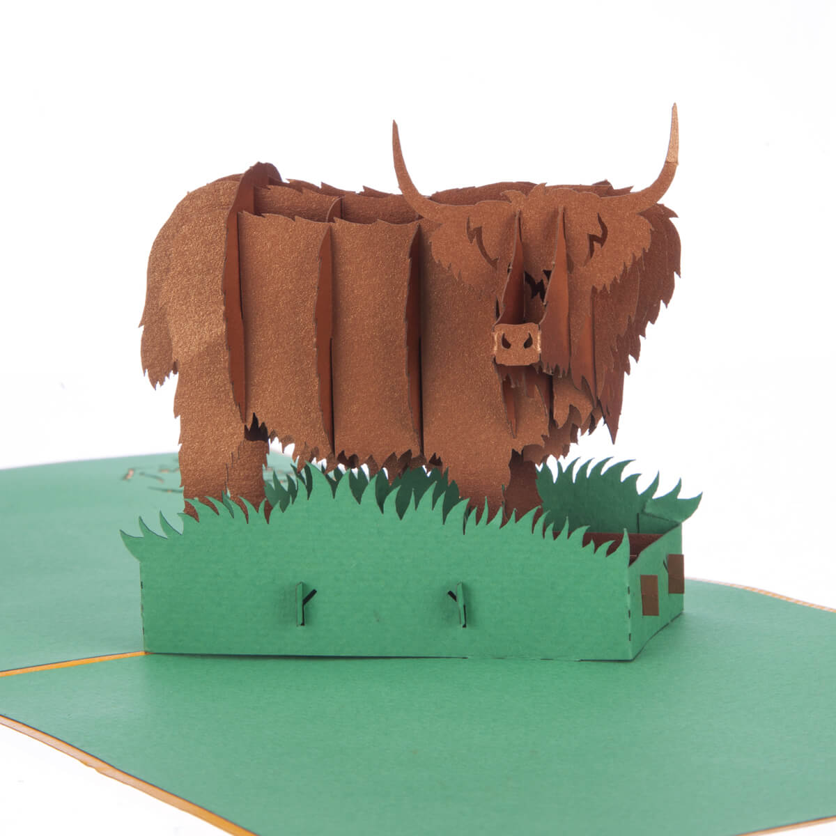 close up image of Highland Cow Pop Up Card featuring a 3D bronze highland cow standing among green grass