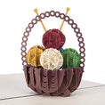 Load image into Gallery viewer, Close up image of knitting pop up card featuring a 3D basket filled with balls of yarn and some knitting needles
