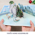 Load image into Gallery viewer, The Snowman Christmas Pop Up Card - Image of hands holding card open
